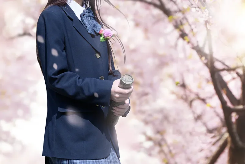 卒業証書を持つ制服姿の卒業記念写真