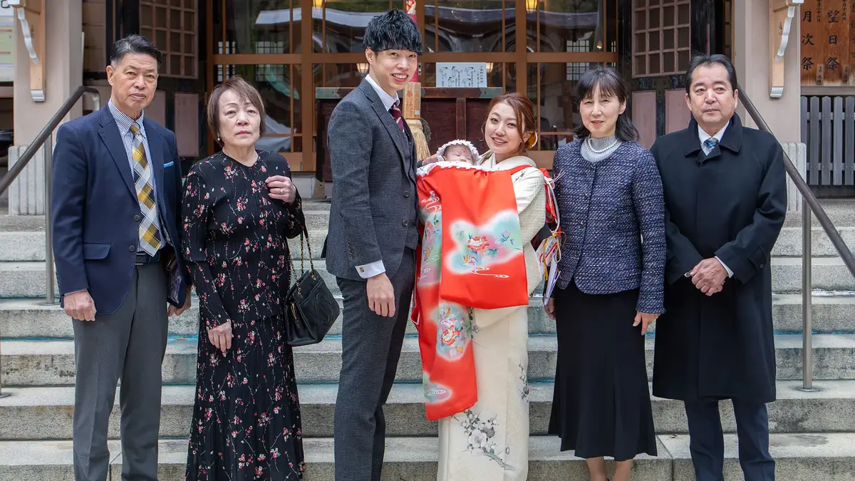 坐摩神社の社殿前で、祖父母・ご両親・赤ちゃんがそろった三世代の家族写真
